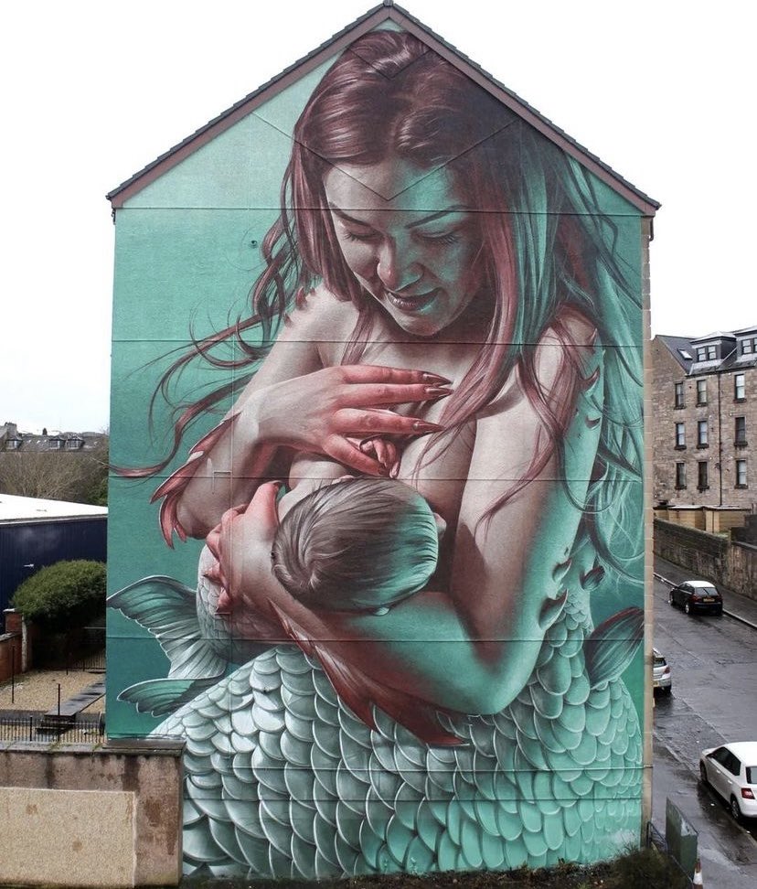 alanferrier's tweet photo. Greenock's latest mural is this stunning image of a breastfeeding mermaid by the artist Sam Bates, aka Smug.

It's on the end of a row of tenements opposite the site of my old school. Aim is to spark conversation &amp; to normalise breastfeeding in the community. 

Photo credit: Smug https://t.co/T0HNP05V9U