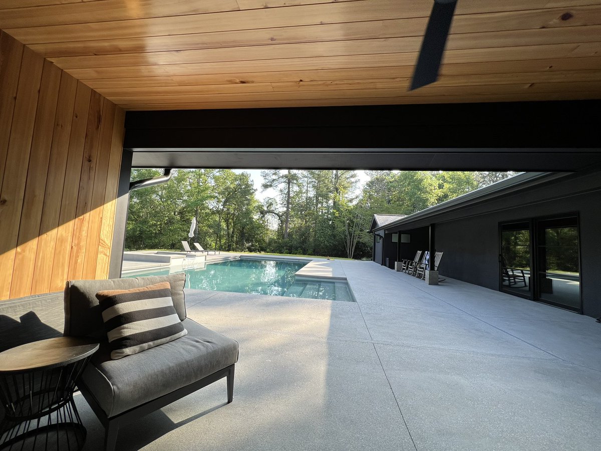 After shot of a remodeled home with a new pool and concrete decking.