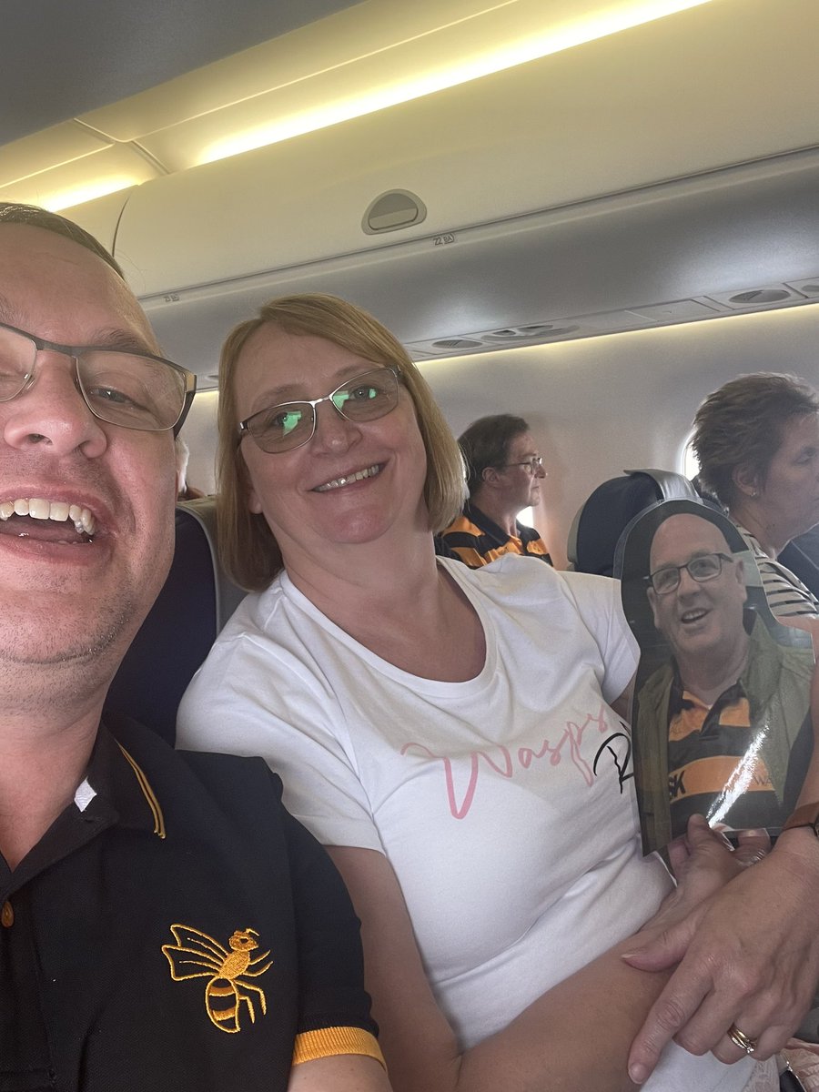 ChrisSpraggett's tweet photo. Straight on the ✈️ that the amazing @GulliversTravel had put on for us. Here’s Mark boarding, realising he’s with the whole @WaspsRugby crew, checking the view and having a cuddle with Jen. #wheresmark #COYW https://t.co/GRX4hi86i2