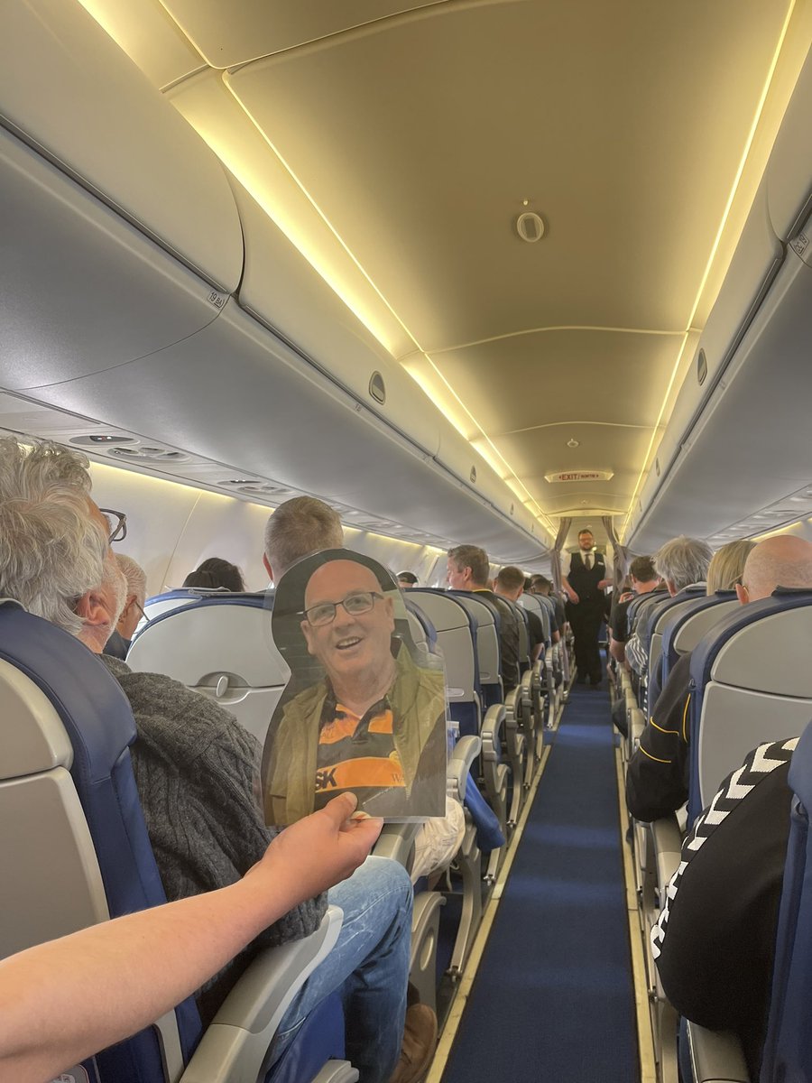 ChrisSpraggett's tweet photo. Straight on the ✈️ that the amazing @GulliversTravel had put on for us. Here’s Mark boarding, realising he’s with the whole @WaspsRugby crew, checking the view and having a cuddle with Jen. #wheresmark #COYW https://t.co/GRX4hi86i2