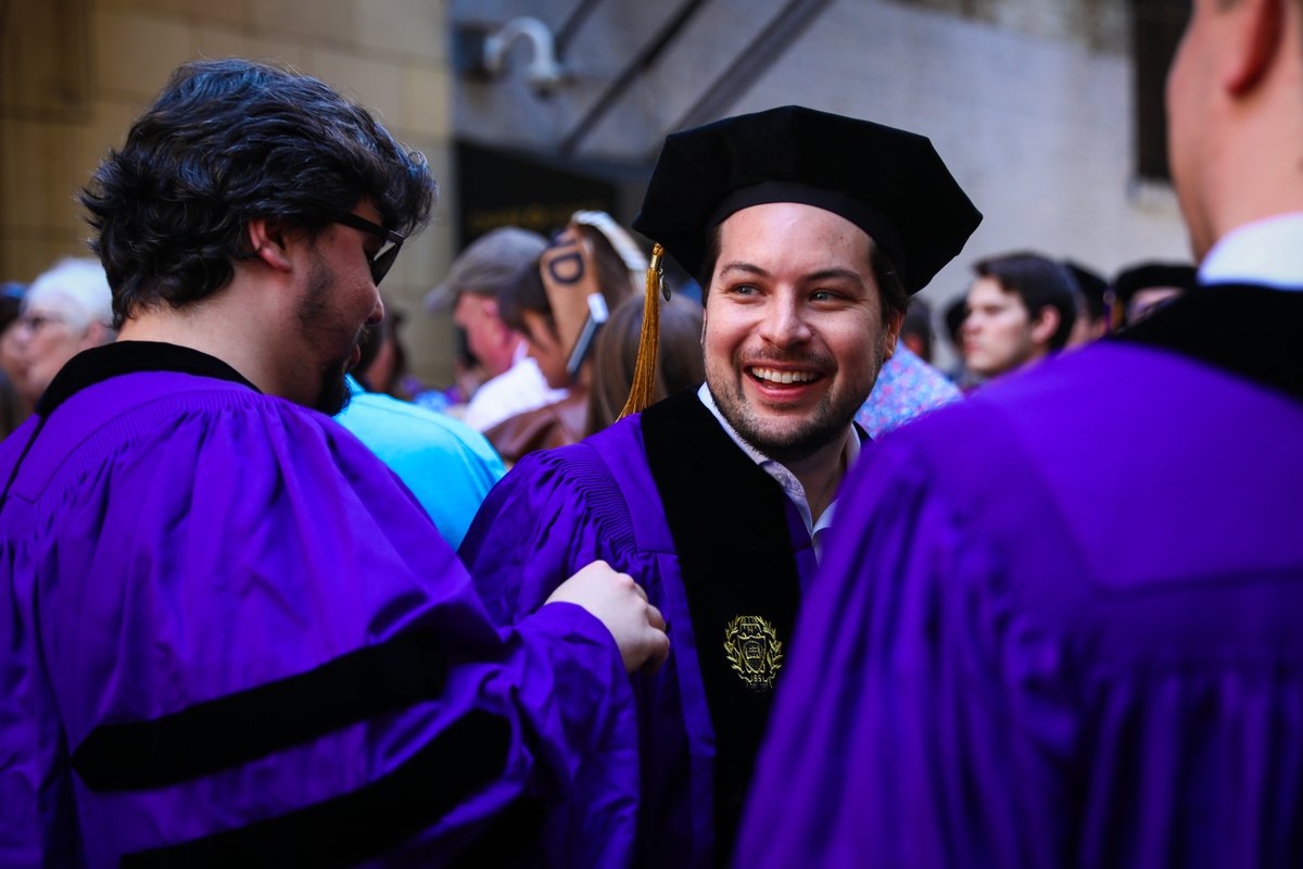 a graduate smiles while standing outside the chicago theatre