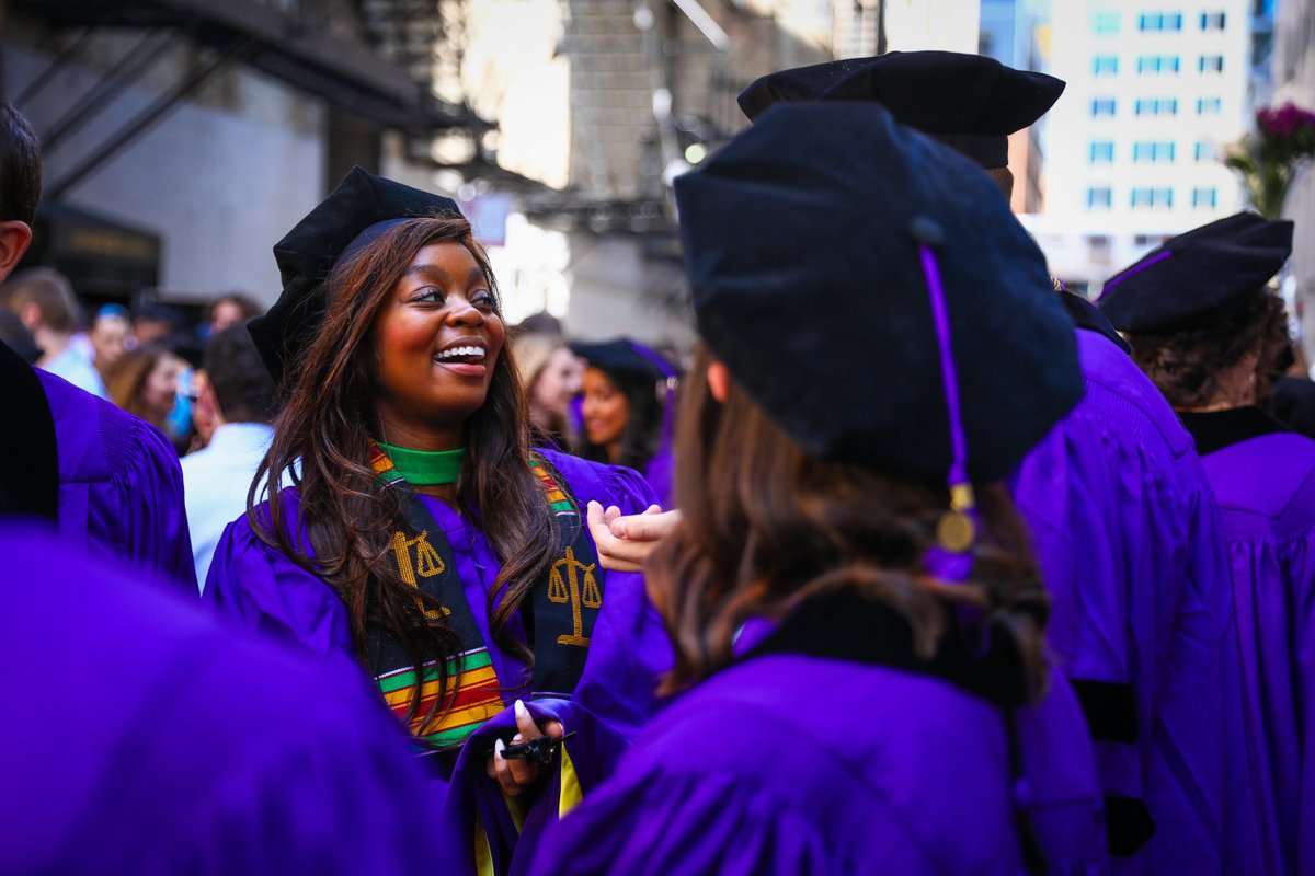 a graduate smiles while standing outside the chicago theatre