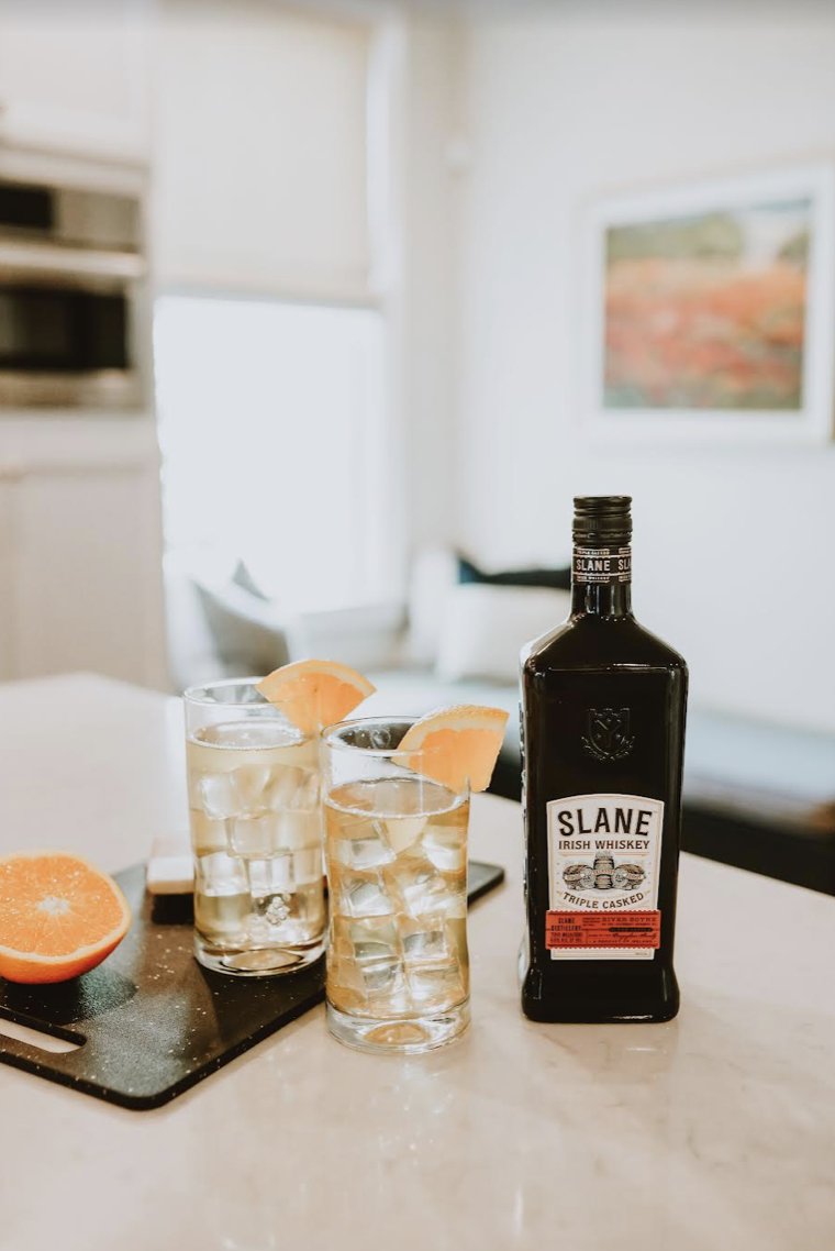 Slane ... but make it summer. The Slane + Ginger: Try Slane Irish Whiskey with a dash of ginger ale garnished with an orange wedge for a easy summer cocktail. #SlaneIrishWhiskey #SlaneWhiskey #Slane #SlaneRocks