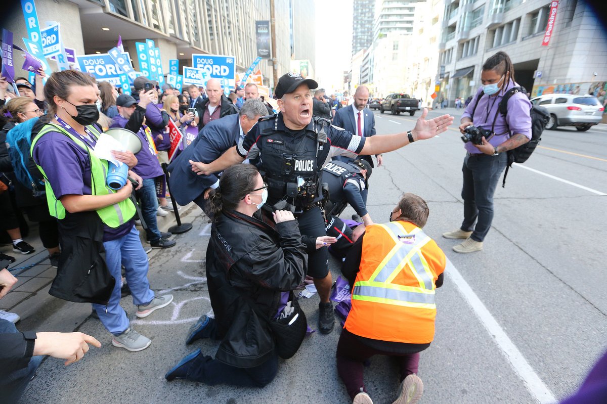 SteveRussell's tweet photo. A member of SEIU, the union that represents nurses, lies injured on Yonge St. after he &amp; others tried to sit in the path that Doug Ford would have taken. Supporters &amp; protesters gathered outside TVO site of the Provincial election leaders debate. #ONpoli #OntarioVotes https://t.co/x3XXOHg8Xm