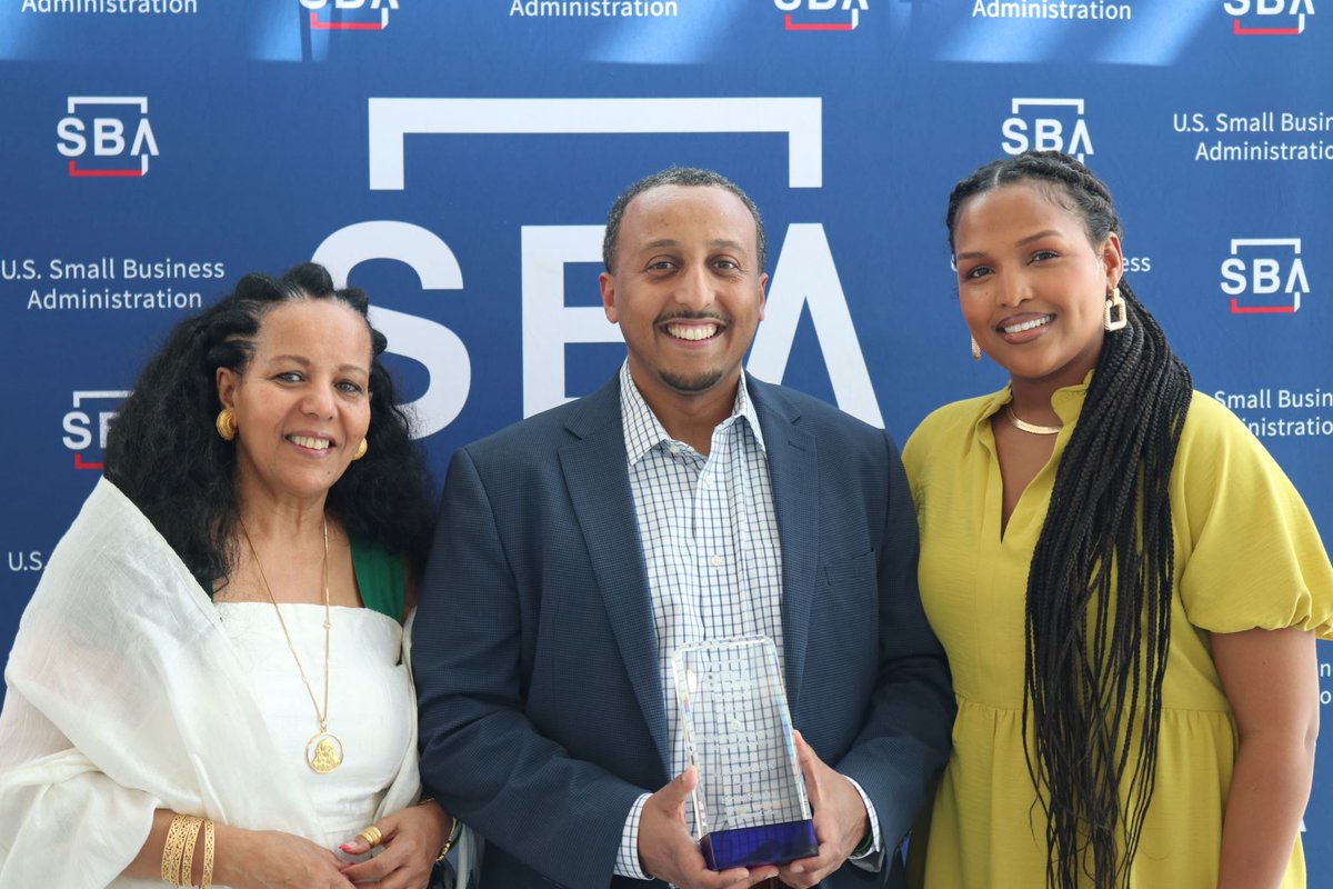 Efrem Fesaha with his award, mother on his right, wife on his left