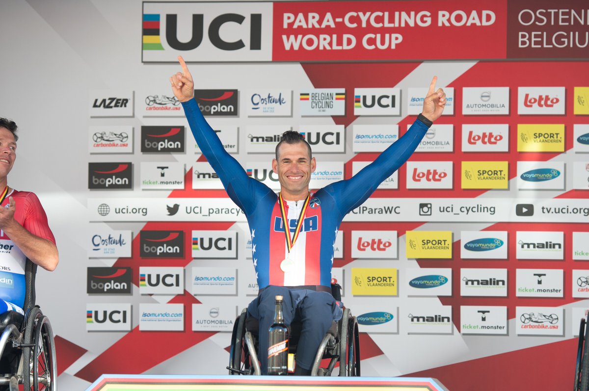 ryan pinney lifts his hands on the podium in celebration