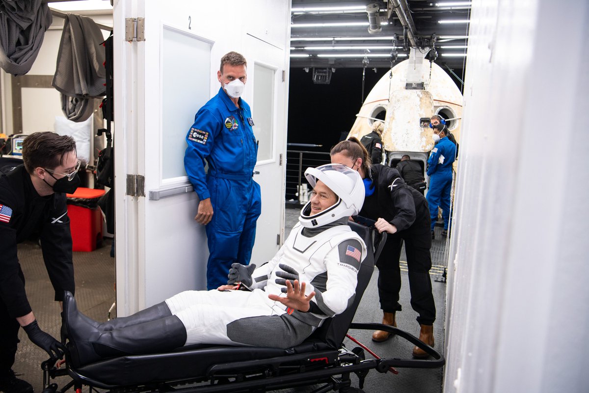 NASA astronaut Tom Marshburn greets friends after being helped out of the SpaceX Crew Dragon Endurance spacecraft onboard the SpaceX Shannon recovery ship.