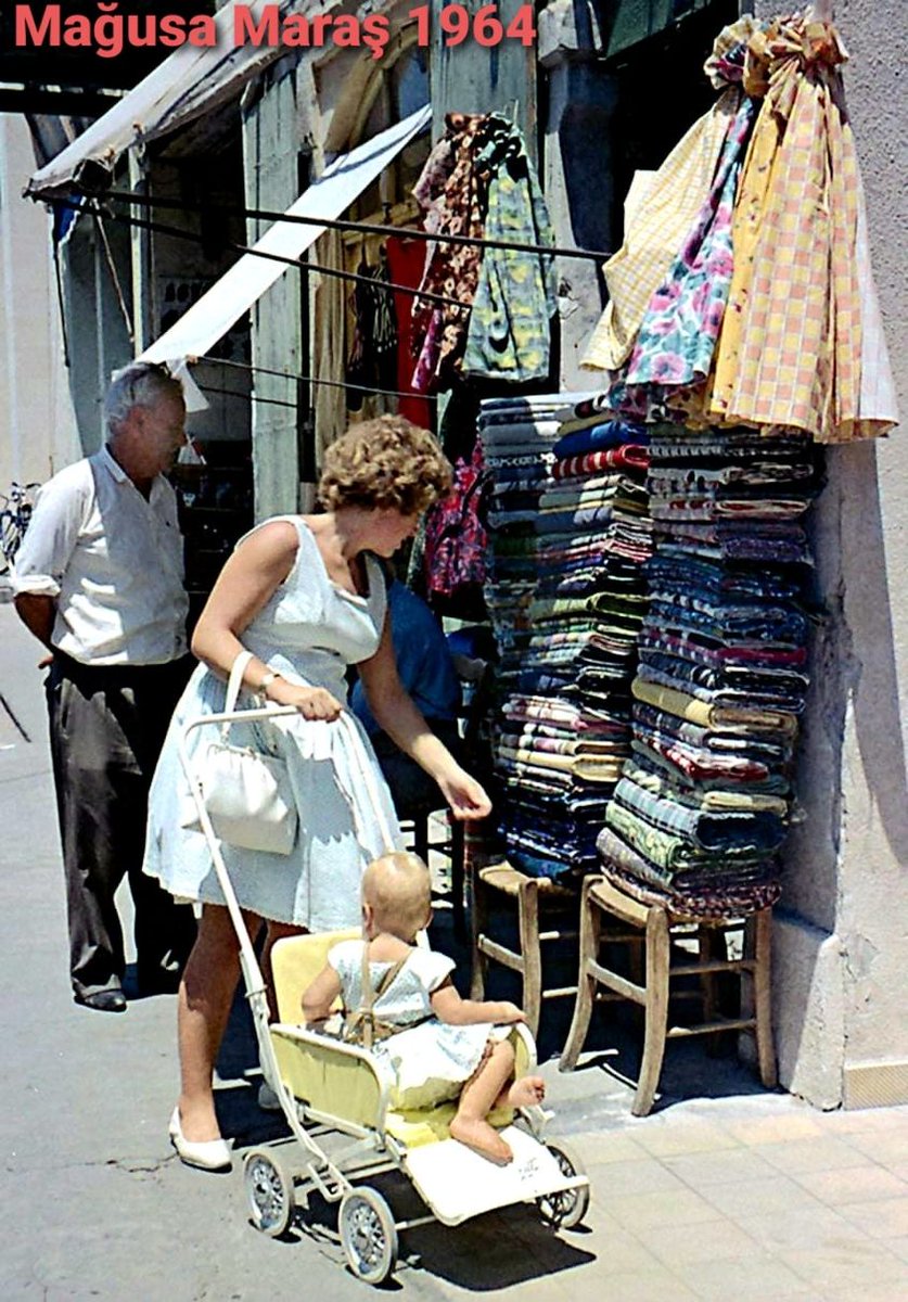 Blueyonetwo's tweet photo. #Varoshia/1964/Under the hot #Cypriot sun/ That baby ought to be wearing a hat/ And so should her Mum/ #Marash/1964/ Sicak #Kibris gunesi altinda alisveris/ Bebek ve annesinin sapkalari yok/ Bugun olsa bu manzarayi goremeyiz! #ClimateChange #Cyprus https://t.co/omg74UmXvo