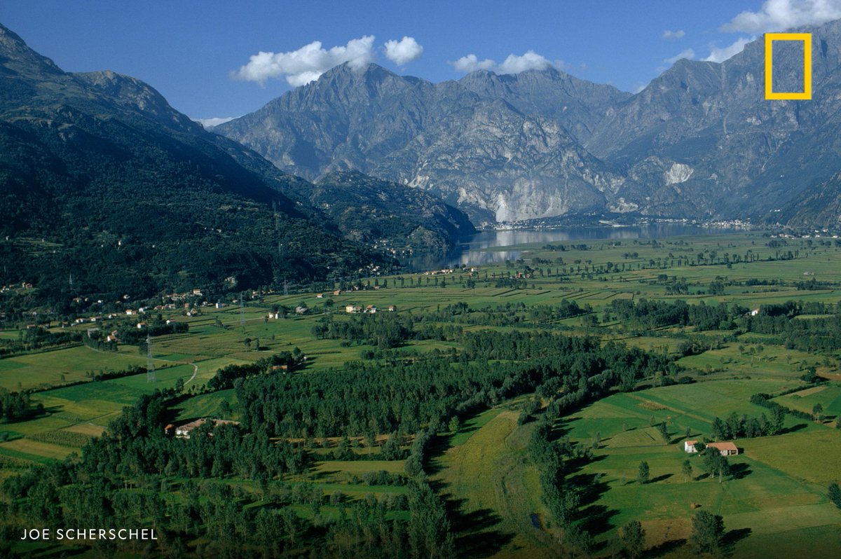 NatGeo's tweet photo. Lush farmland and snow-laced mountains border Italy's Lake Mezzola in this image from our archives https://t.co/BqmatZDq2S