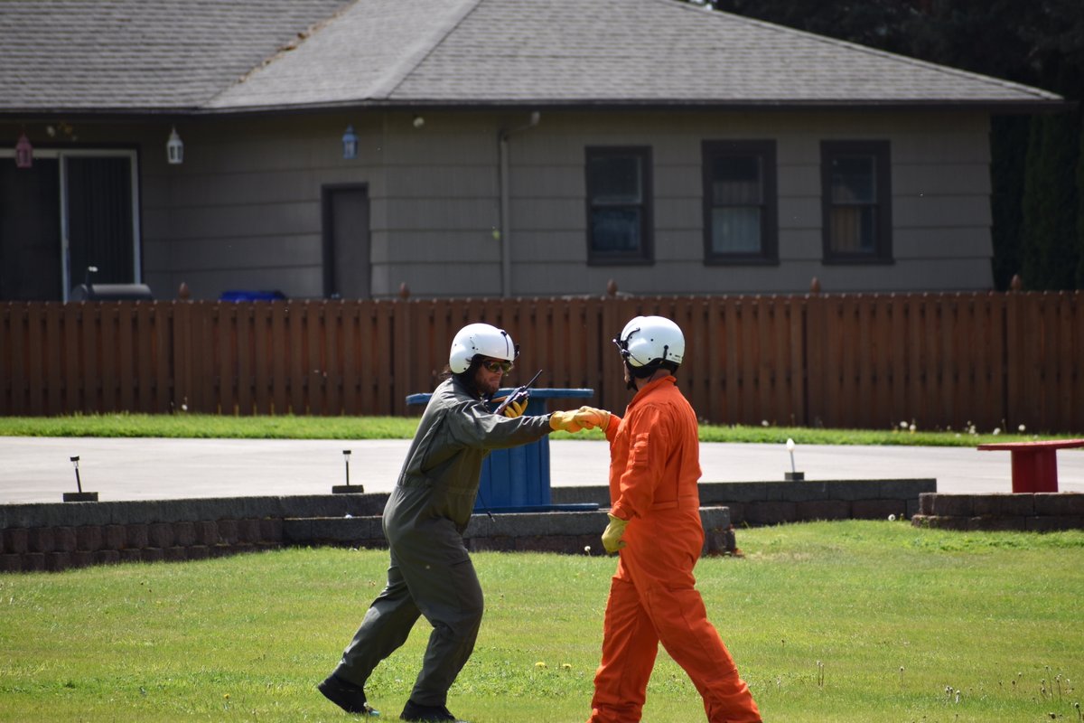 Two men in flight suits fist bump.