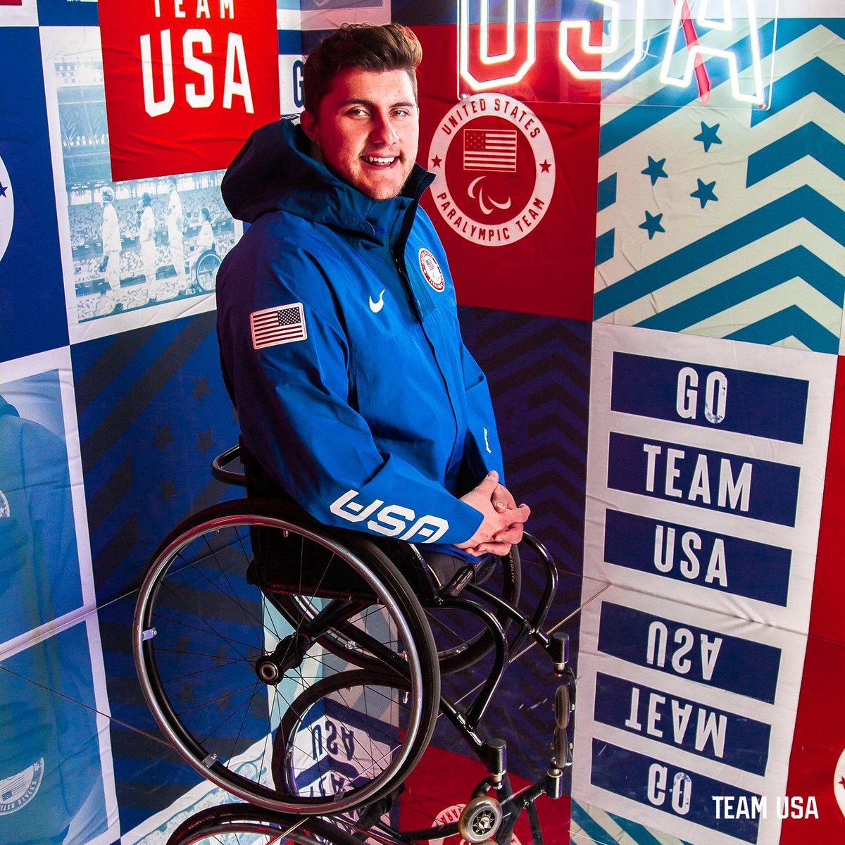 Image of sled hockey player Brody Roybal pictured smiling on a Team USA neon light set 