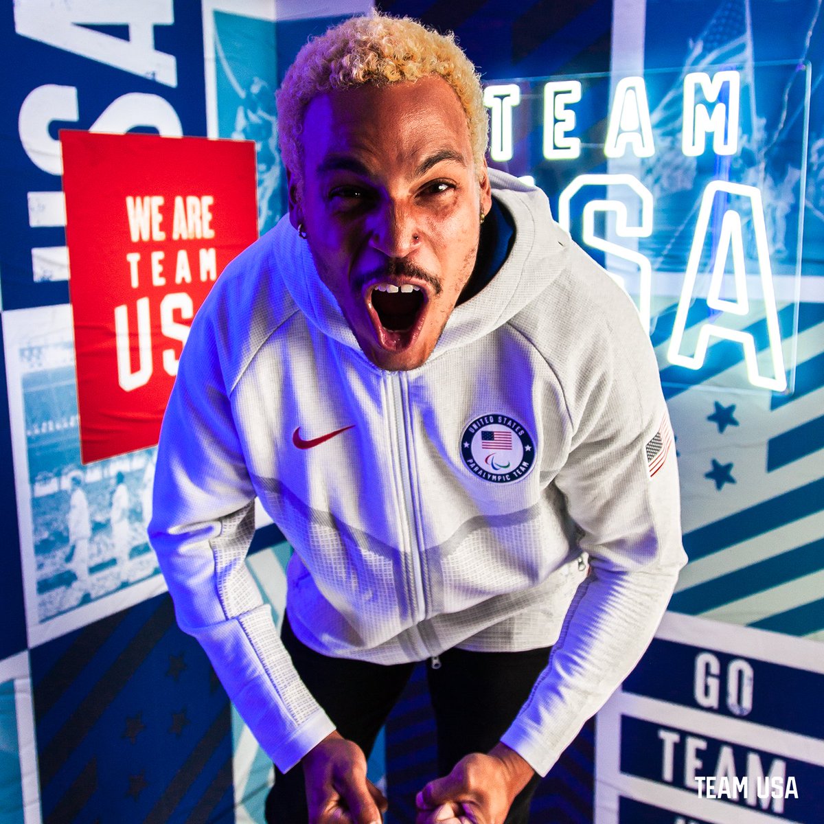 Image of Para track and field athlete Roderick Townsend screaming into camera on a Team USA neon light set 