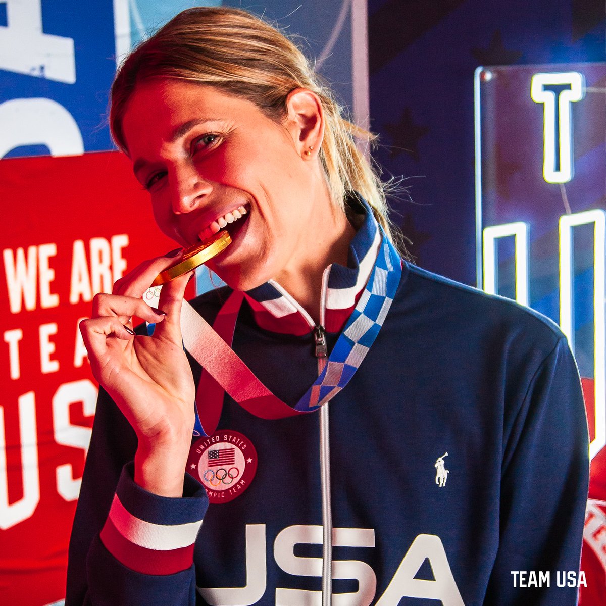 Image of beach volleyball player Alix Klineman smiling on a Team USA neon light set 