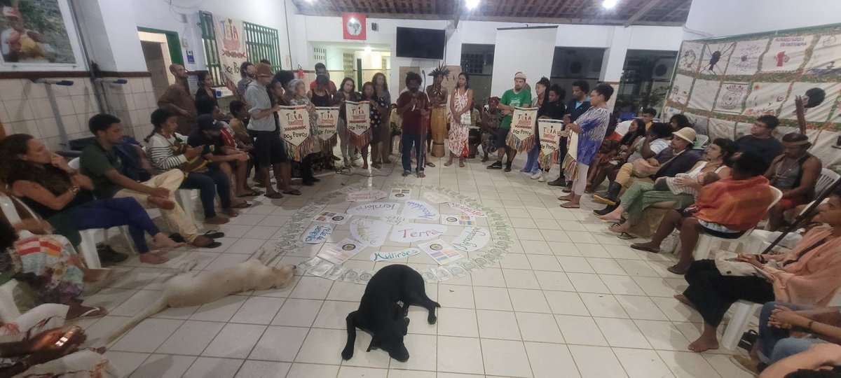Celebração de 10 anos da <a href="/teiadospovos/">Teia dos Povos #Levantepelaterra</a> da Bahia. Leitura da Carta final do I Encontro Nacional das Teias. O que nos une é maior daquilo que nos separa. Por terra, território e bem viver avançaremos sem negociar nossos princípios. Guiados pela ancestralidade, partimos para guerra!