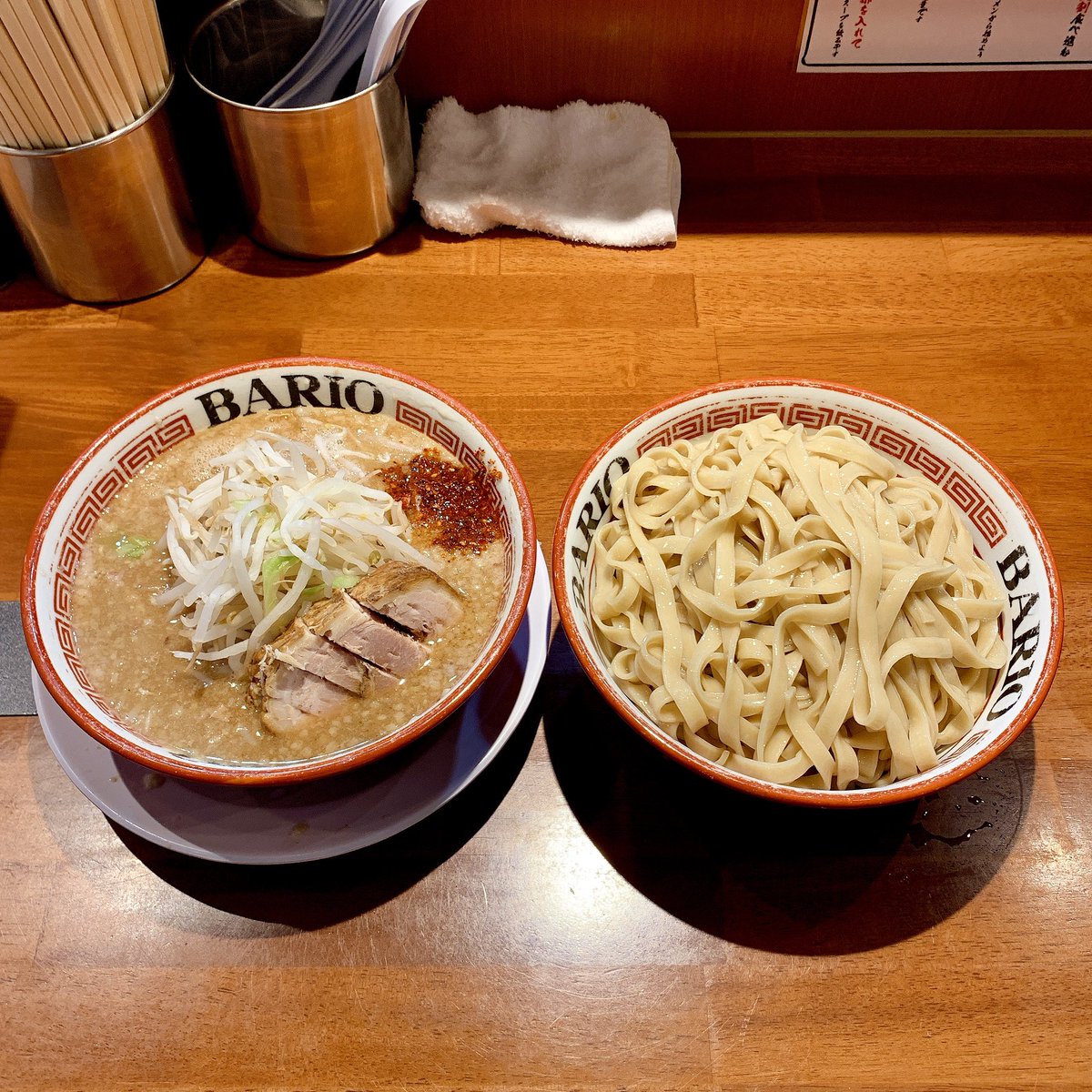 らーめん バリ男 大森店 大盛りつけ麺 1000 二郎系なのに平打ち麺がツルッとピロッとして面白い つけ汁は豚骨ベースっぽいけど酸味の強い醤油で二郎な味わい 丼の奥の唐花は意外と辛味が強く混ぜると結構なアクセント 後半は付属のフリーニンニクをたっぷり入れて野菜