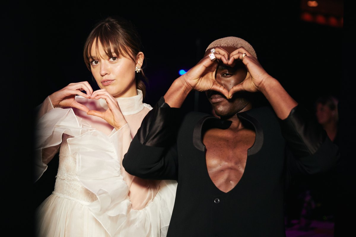 A set of photos backstage at the Virgin Media BAFTAs.

Aimee Lou Wood and Ncuti Gatwa make heart shapes with their hands to camera 