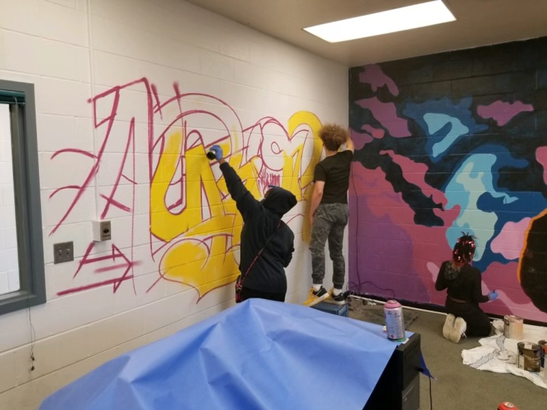 CincyPD's tweet photo. In the summer of '20, Police Cadet Aurora McCarter tragically lost her life to gun violence. In July of '21, a room at our Youth Services Unit building was dedicated to Aurora. The room was painted by local artists w/ the input &amp; help of our cadets to honor Aurora @Brentlavelle1 https://t.co/hVzEj9mXAF