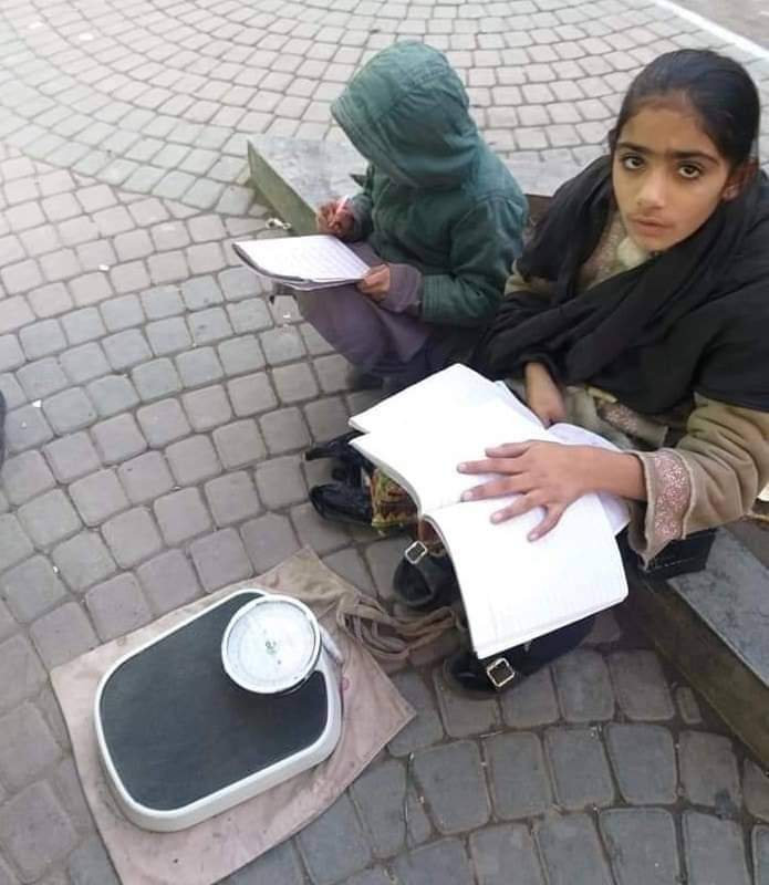 SanaYousafzai9's tweet photo. Uzma and her younger brother Mohammad do their homework while sitting next to a weighing machine in Peshawar Saddar. Their father sells balloons and both are passionate about continuing their studies. https://t.co/YahAk8Uyky
