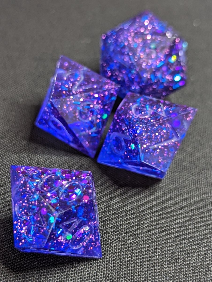 FishMakesDice's tweet photo. Pull of the day! Meant to be a sort of...galactic glitter explosion. Bit of a sinking issue with the larger glitter though, so now all the high faces are extra glittery.

#handmadedice #dice #dicemaker #ttrpg #dnd #dungeonsanddragons #diceset #dnddice #resin #resinart #mathrocks https://t.co/aX4hYBa0SY