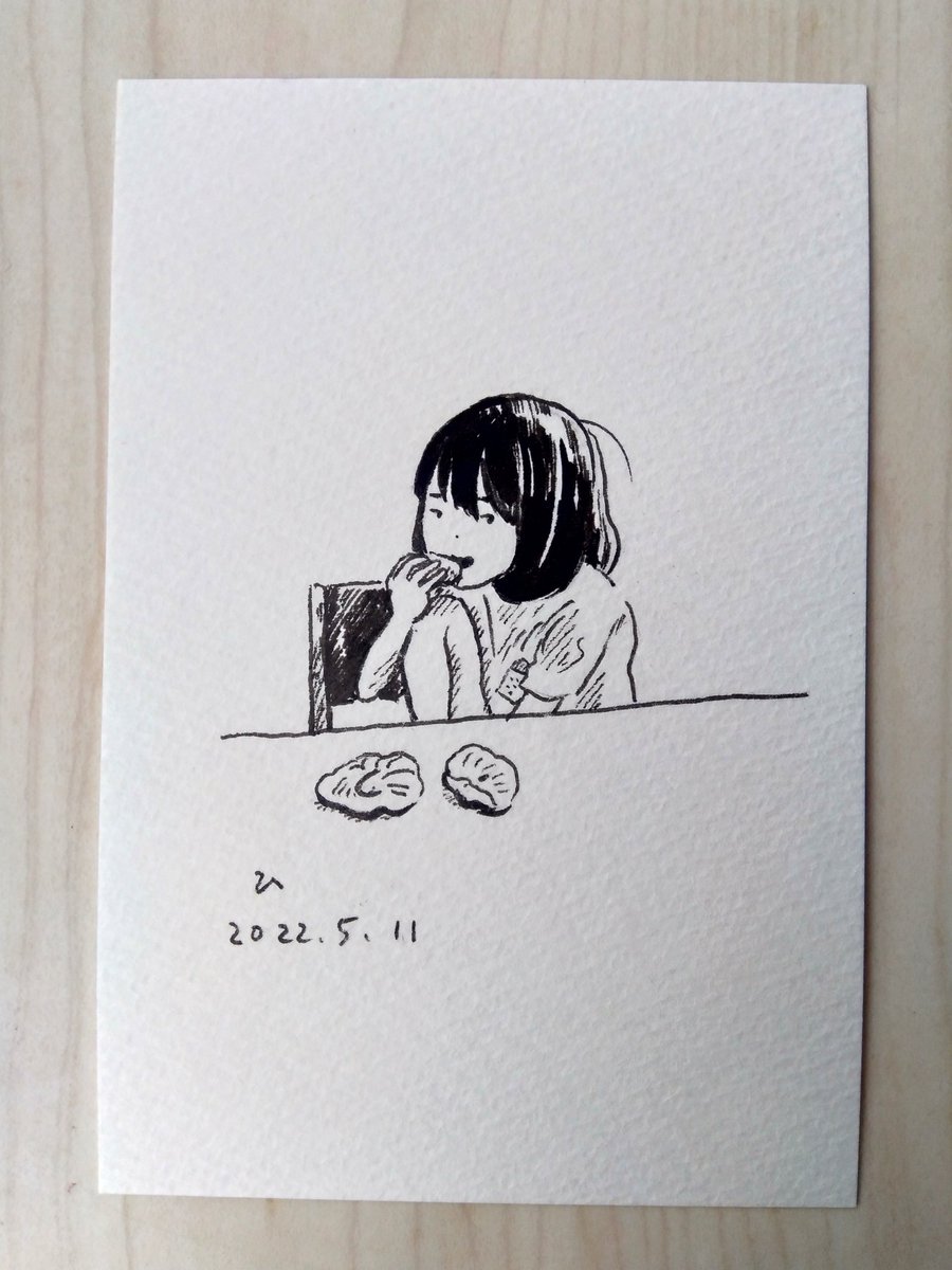 皿を使わず、テーブルに直接パンを置いて食べる娘(ハムチーズと胡桃パン) 
