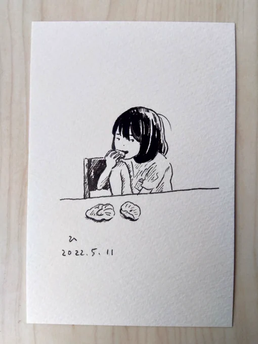 皿を使わず、テーブルに直接パンを置いて食べる娘(ハムチーズと胡桃パン) 