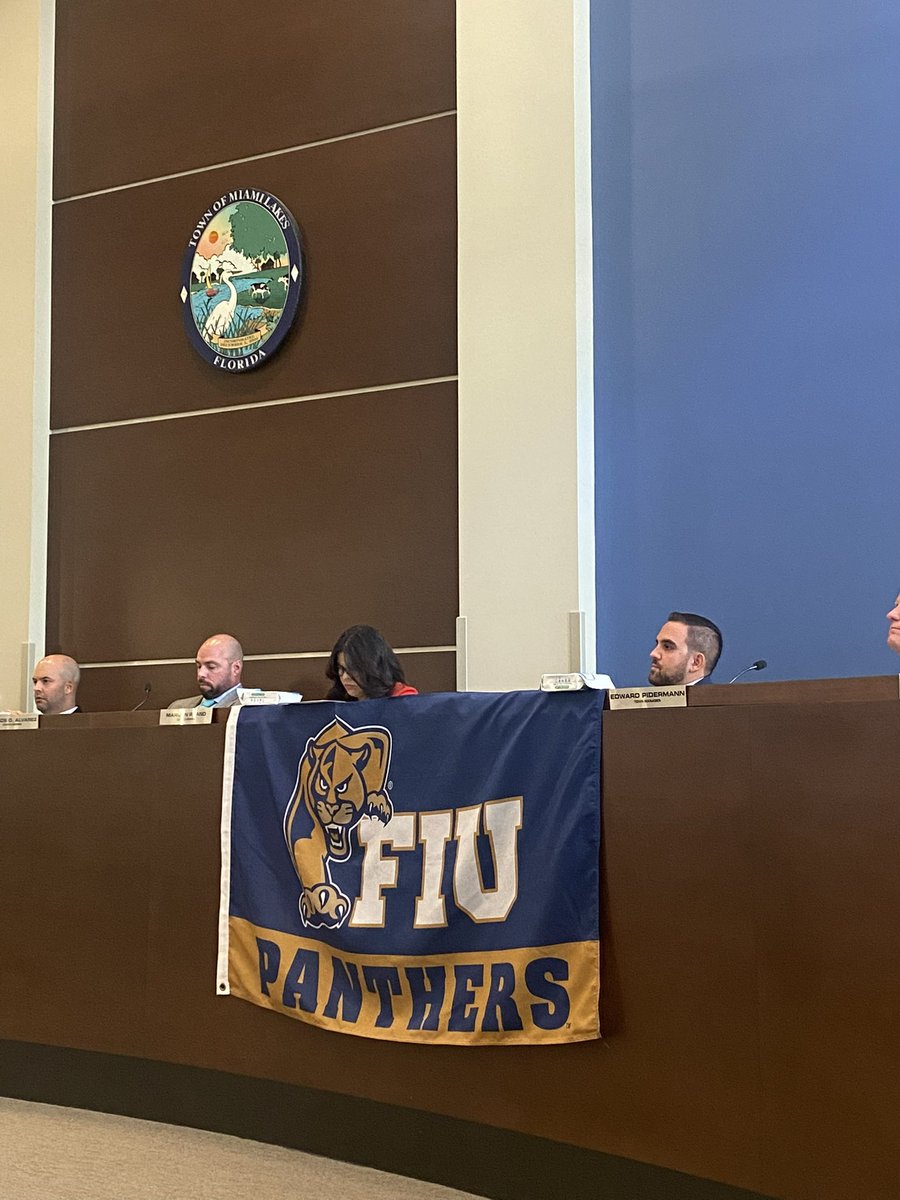 JoshDieguez's tweet photo. I was happy to join my fellow @FIU alum and Council colleague, Luis E. Collazo, and former classmate @BryanMorera in welcoming @FIUPresident to Town Hall. We headed up to my office to pose with my FIU flag, which is now hanging on the dais for the duration of the meeting! #PawsUp https://t.co/jJnyeuAnpJ