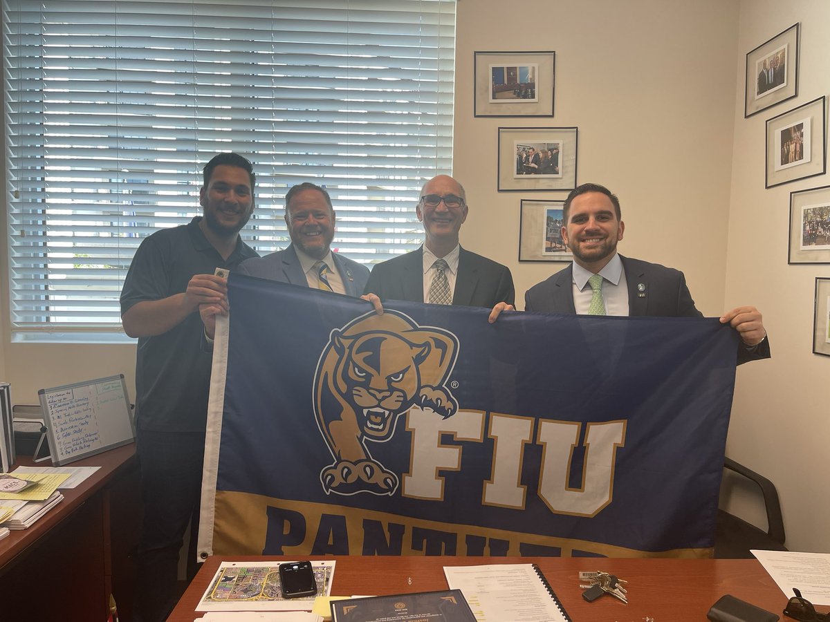 JoshDieguez's tweet photo. I was happy to join my fellow @FIU alum and Council colleague, Luis E. Collazo, and former classmate @BryanMorera in welcoming @FIUPresident to Town Hall. We headed up to my office to pose with my FIU flag, which is now hanging on the dais for the duration of the meeting! #PawsUp https://t.co/jJnyeuAnpJ