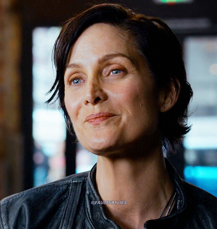 Trinity from The Matrix Resurrections smiling back at Neo