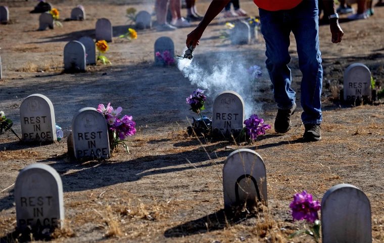 Tiny gravestones being smudged in a purification/healing ceremony. At least 500 Indigenous children (tentative conservative estimate) died in U.S. boarding schools, according to a recent report released by the Interior Department.