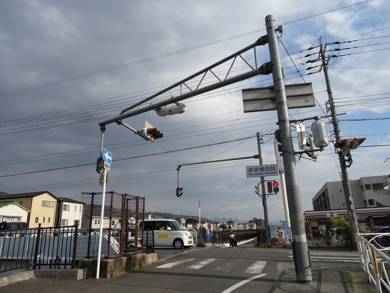 たこ 道路好団垢 種明かし 川沿いに信号柱 を立てる事が困難なため なんと道の反対側からアームを伸ばし 様々な方向の信号機を1つの柱に設置しています 大阪府独特の類稀な設置方法です 八尾市の 薬師橋西詰 交差点 薬師橋東詰 交差点にて
