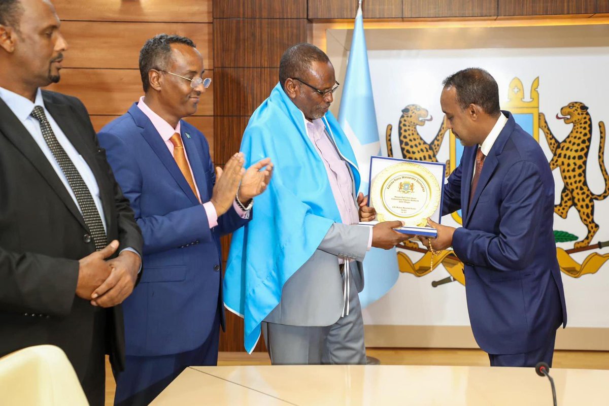 HarunMaruf's tweet photo. BREAKING: As a symbol of deepest apology, Somali PM @MohamedHRoble gives the Somali national flag to ONLF commander Abdikarim Muse Qalbi Dhagah. https://t.co/jx0qQ4Vcmn