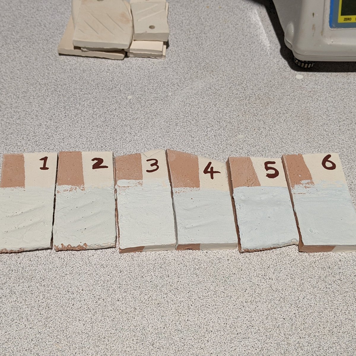 6 numbered ceramic tiles with raw glaze mixture on