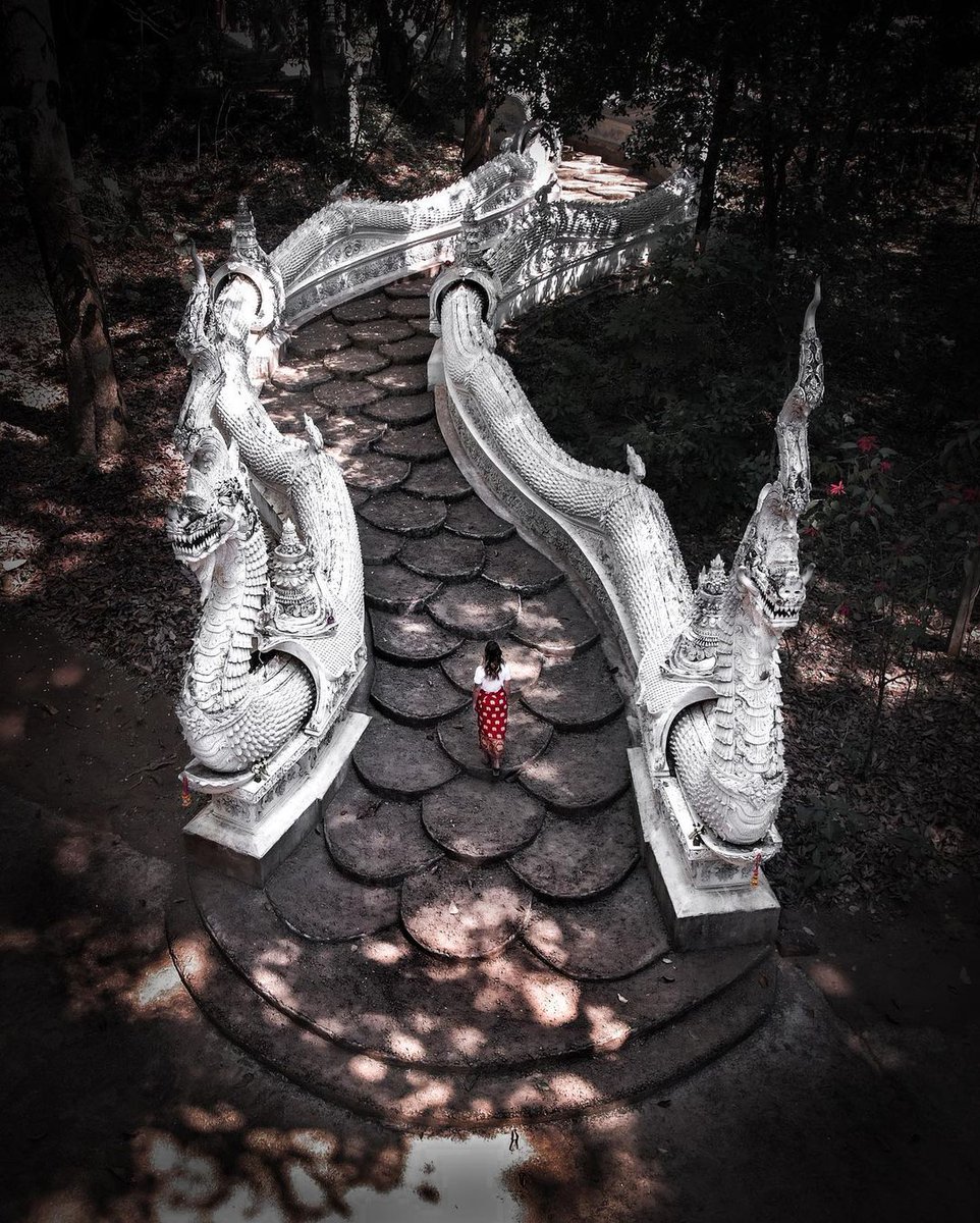 Situé au milieu de la #forêt dans la province de #ChiangMai, le #temple Wat Luang Khun Win règne dans une atmosphère envoutante. Vieux de 700 ans avec ses spirales en forme de dragon et ses flèches dorées, ce temple caché semble sortir tout droit du sol de la forêt.

📸:@johndlms
