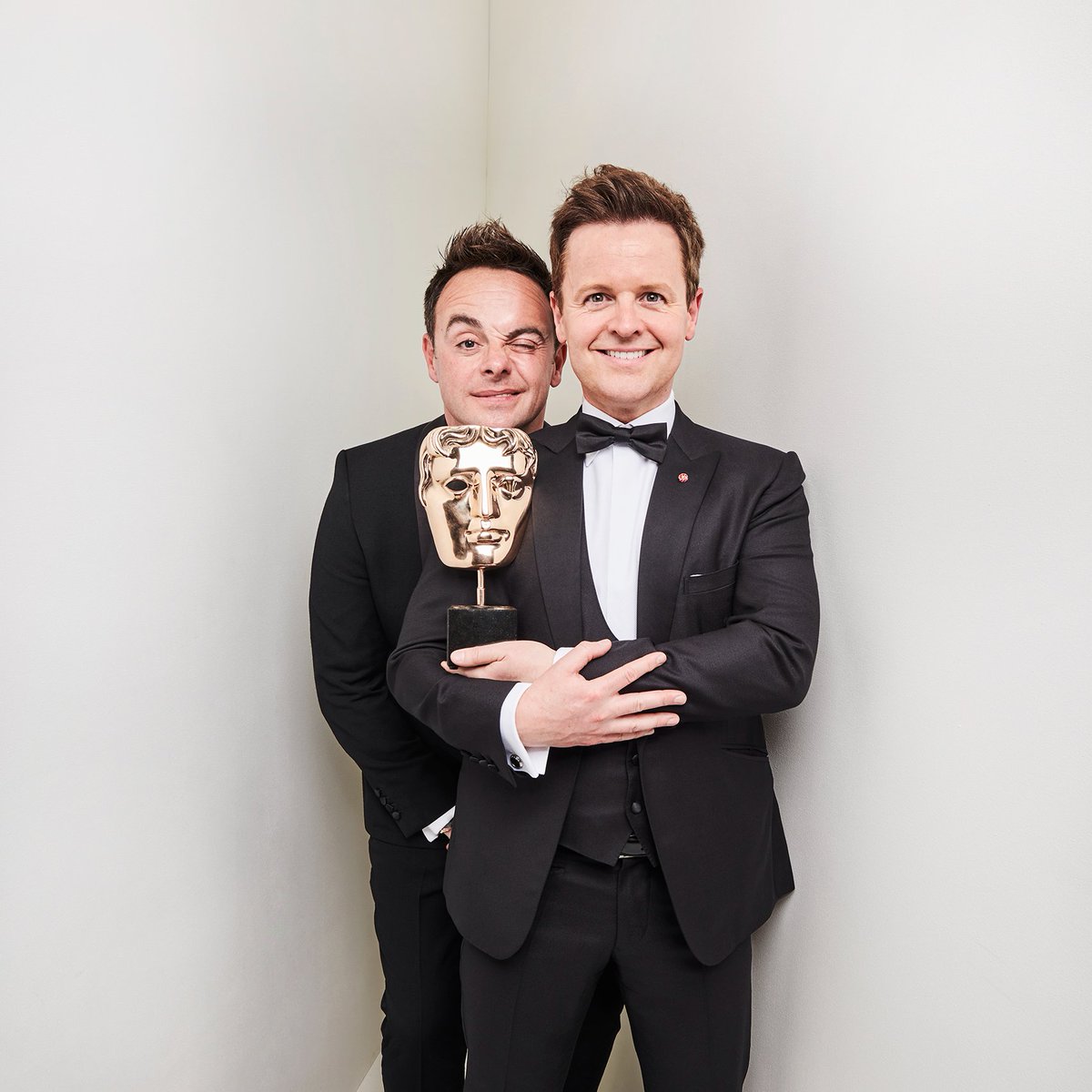 Ant and Dec hold their BAFTA. Ant winks at the camera
