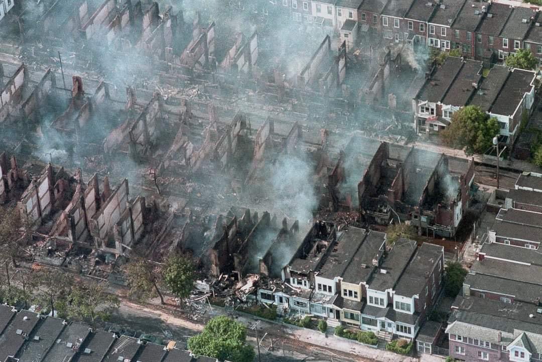 AfricanArchives's tweet photo. On this day in 1985, Philadelphia Police Department dropped a bomb onto a residential home occupied by the MOVE Organization following a standoff. 

The Fire Department let the fire burn out of control, destroying 61 homes over two city blocks. 11 people died including 6 children https://t.co/jd3XKGcQkW