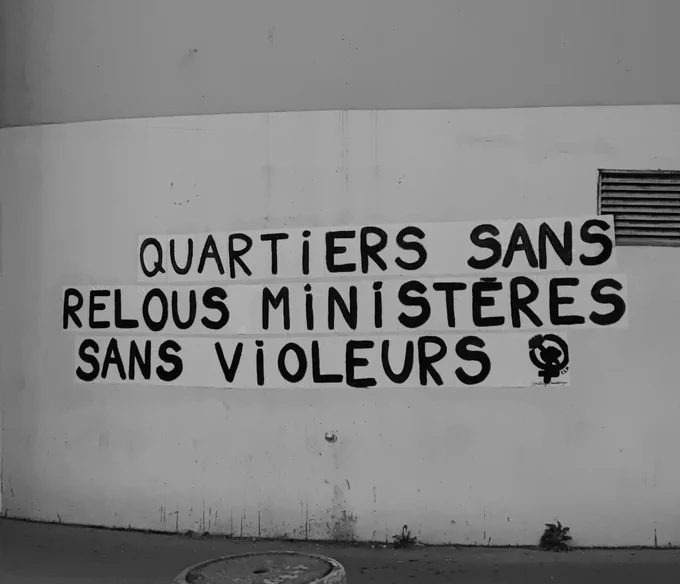 photo en noir et blanc d'un collage sur un mur : "Quartiers sans relous, ministères sans violeurs"