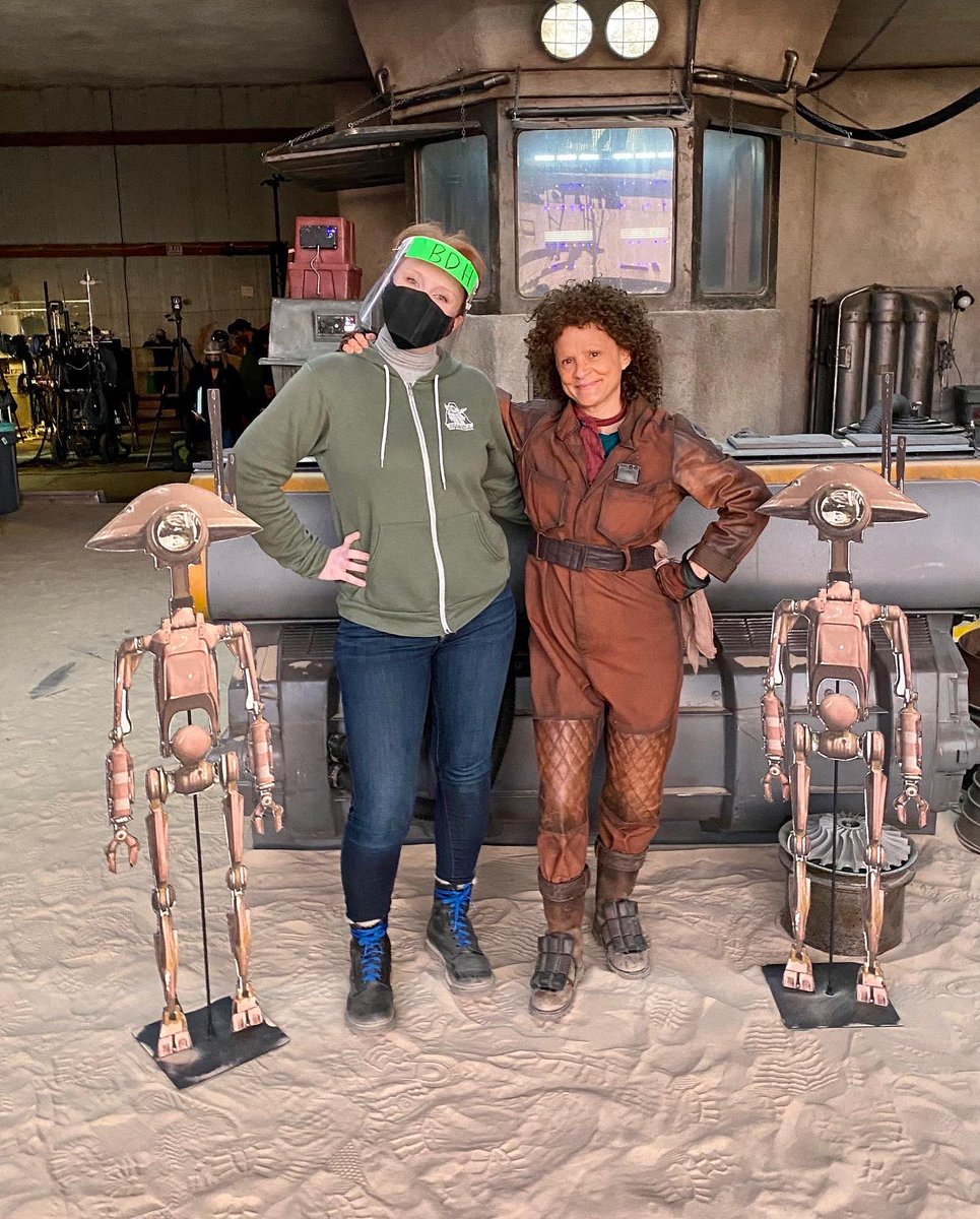 BDH, Peli Motto, and two pit droids take a break from building Mando’s ship to smile for a photo inside of Peli’s Hangar on Tatooine.