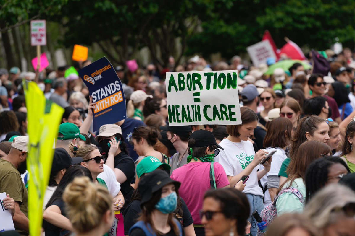 Protesters in Brooklyn carry signs reading “Abortion is Health Care.”
