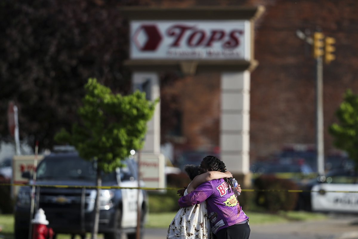 CBSNews's tweet photo. People gather outside of a supermarket in Buffalo, NY as police investigate a mass shooting that took place on Saturday. Police said the shooter has been charged with murder in what officials are calling a case of racially motivated violent extremism. https://t.co/xs7RZUcII4 https://t.co/1iQyQwqd9M