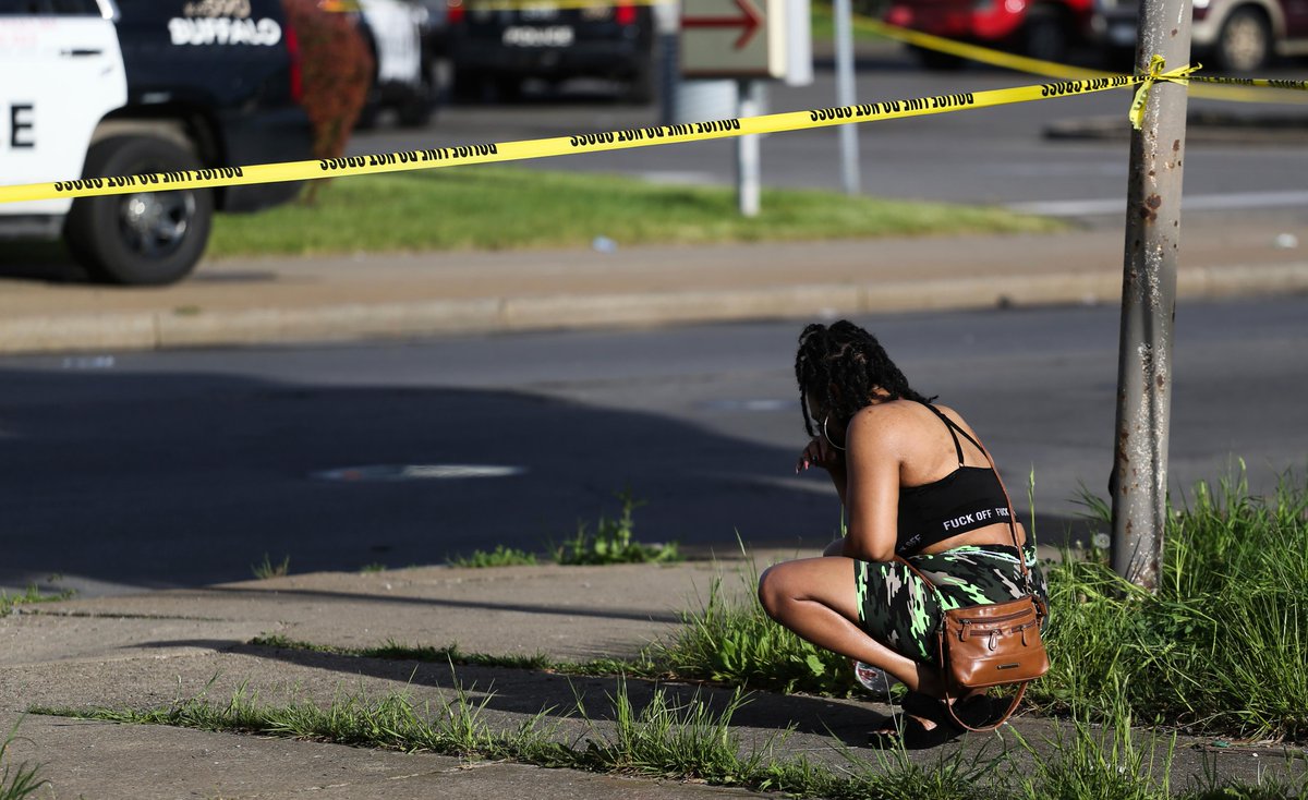 CBSNews's tweet photo. People gather outside of a supermarket in Buffalo, NY as police investigate a mass shooting that took place on Saturday. Police said the shooter has been charged with murder in what officials are calling a case of racially motivated violent extremism. https://t.co/xs7RZUcII4 https://t.co/1iQyQwqd9M