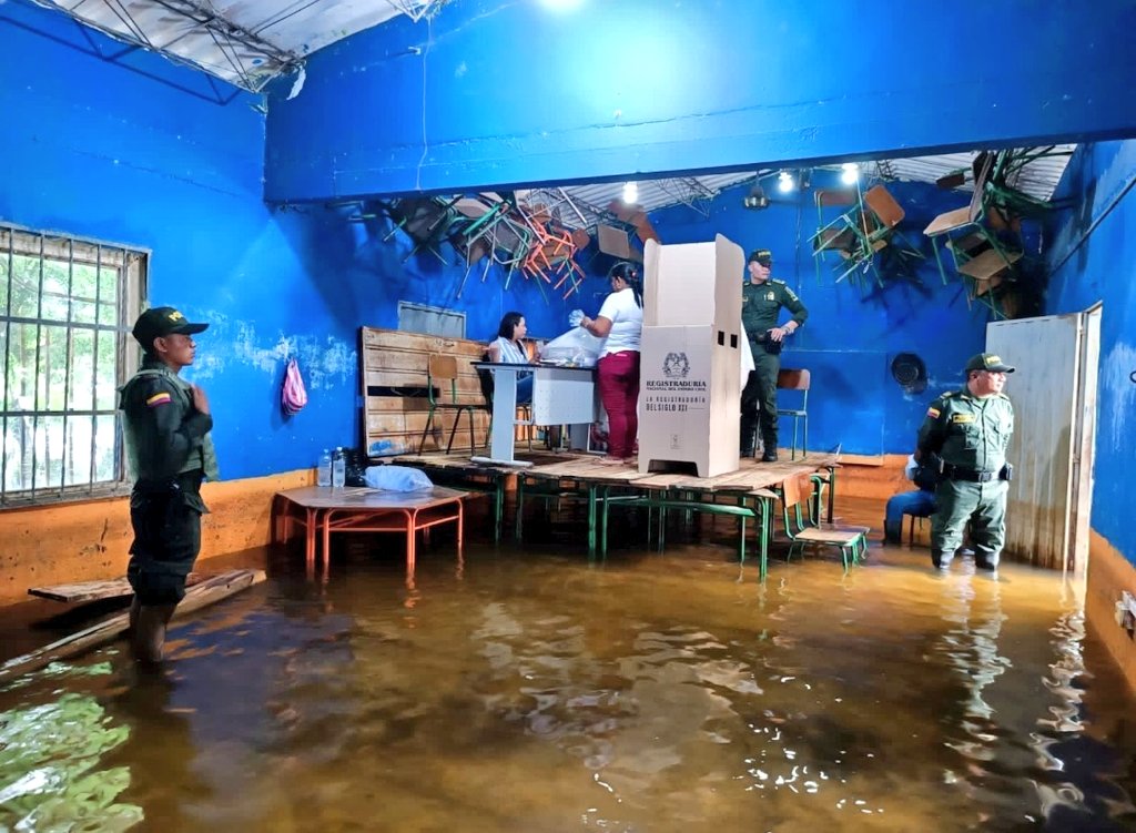 Las dos fotos del día. Votando sobre una alfombra y votando inundados de agua. COLOMBIA en dos fotos