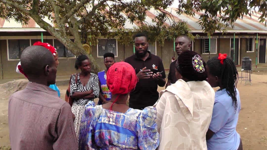BACK TO SCHOOL TIME. Our Team Leader <a href="/FredrickIMS/">Fredrick IMS Kayiira</a>  and Mr Mukasa, the Project field Coordinator in a conversation with Parents, who returned their Children to School under <a href="/mtoto_Wa_shule/">Initiative for Mtoto Wa Shule (IMS)</a> PEIS CHILD EDUCATION INSURANCE POLICY at Kifukamiza Primary School,  Kyotera district.