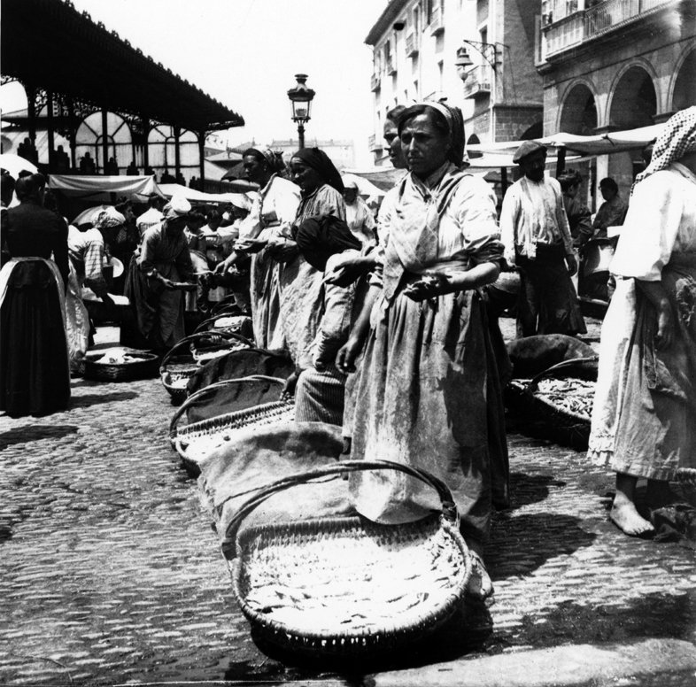 Erretratu, ikuspegi orokorra, non arrain-saltzaileen postuak agertzen dira, galtzada-harrien gainean, plaza zaharran. Erribera kaleko arkuak eta Julian Saracibar arkitektuaren merkatuko pabiloi zati bat ikusten dira.

📷Abaitua Allende-Salazar, Eulalia 
Circa 1895

@museo_vasco