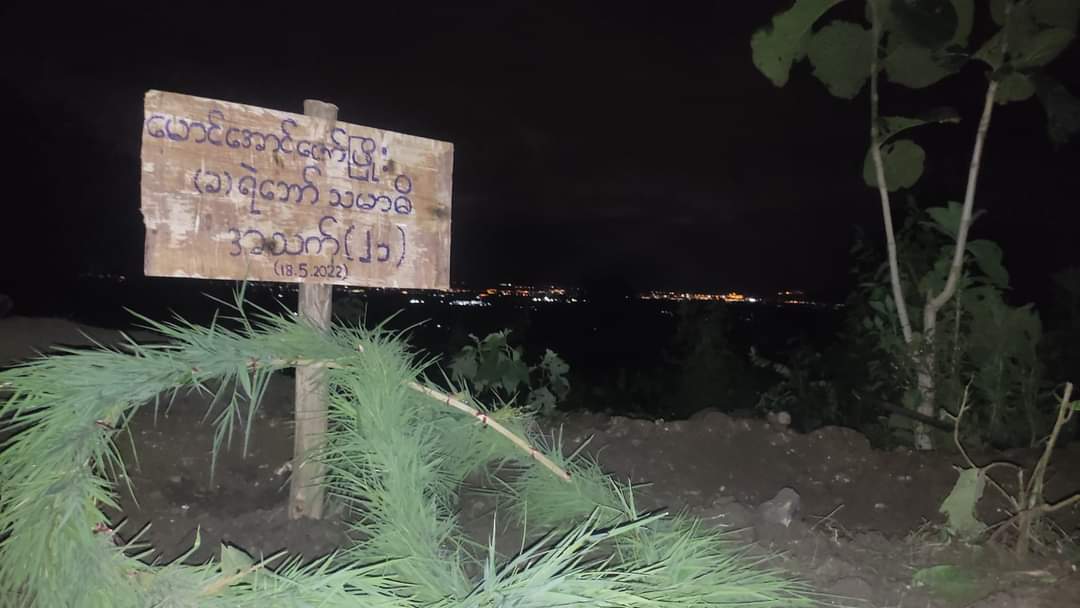 Chanapai247's tweet photo. Photo of the day.

A burial mound of a PDF comrade (Mg Aung Zaw Phyoe) and colorful night of Thailand in one frame. 

The world is unfair 💔

#2022May18Coup 
#WhatsHappeningInMyanmar https://t.co/AolGdSK2hp