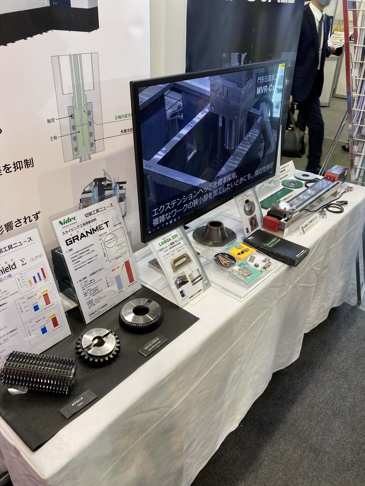 日本電産マシンツール 公式 肝心の展示内容はこちら 奥から Mpスケール Lamda 3dプリンタ サンプル 精切削工具 スカイビングカッタ ホブカッタ モニターは門形五面加工機mvr Cxでタペストリーはmvr Hxっと もりだくさん Mex