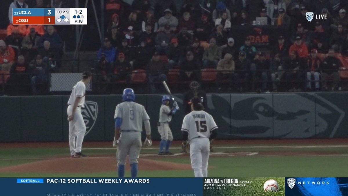 It's UCLA vs Oregon State, and the Oregon State pitcher is a very tall man, and Kenny Oyama is 5'4" and looks about four feet tall because there is a shortstop and a man on second in the foreground