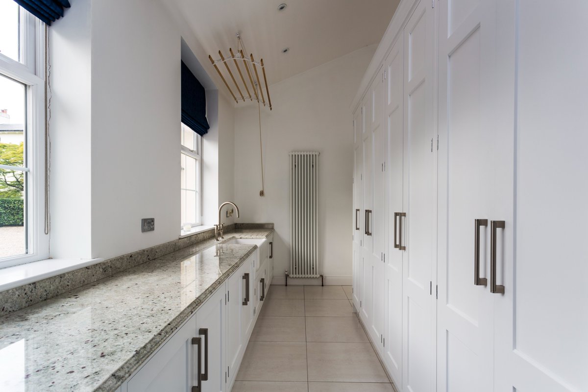 Wonderful run of cupboards in this utility room, by John Ladbury. Granite worktops with a Perrin and Rowe tap and Shaw's butler sink. #johnladbury #utilityroom #graniteworktop #hertfordkitchens #Londonkitchens #kitcheninspo #dreamhome #houseandgarden #interiors #designer #homes