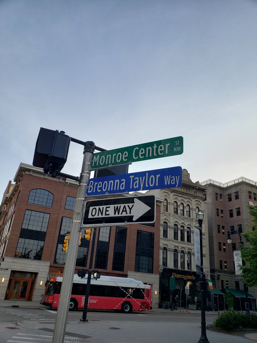 Two street signs on a street corner. The top reads Monroe Center St. The lower reads Breonna Taylor Way. 