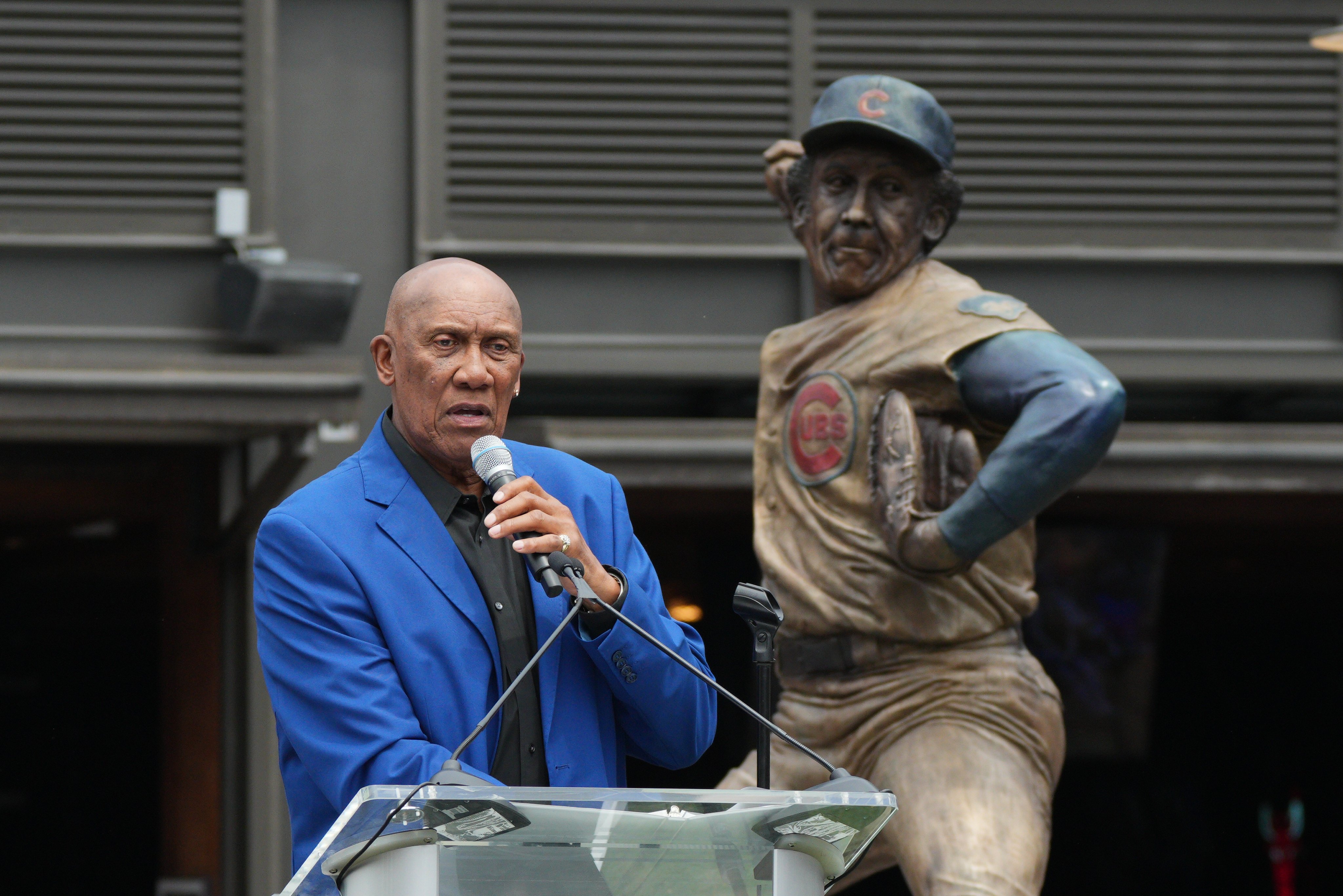 Fergie Jenkins addresses the crowd at Gallagher way with his unveiled statue behind him. 