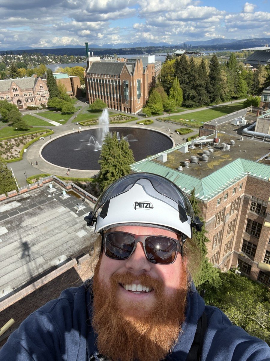 Selfie taken by a PNSN field tech atop the tower on the ATG roof. Behind him is Drumheller Fountain, the ECE building, and Lake Washington in the distance.